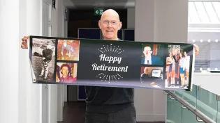A photo of Porteous holding happy retirement banner