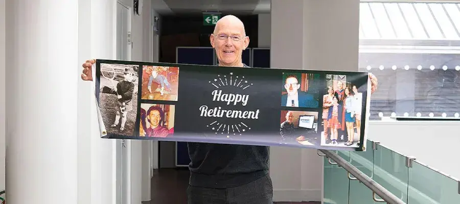 A photo of Porteous holding happy retirement banner