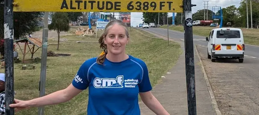 Amy under a sign showing that this is as the equator