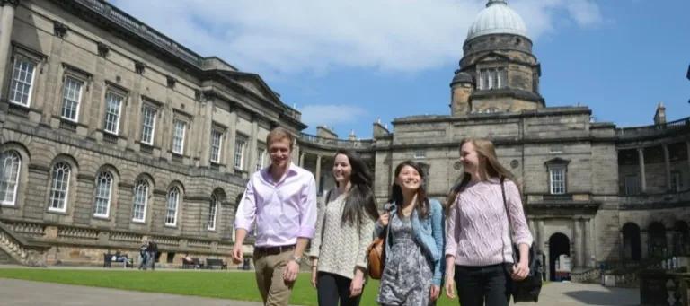 A picture of four students walking in the Old College