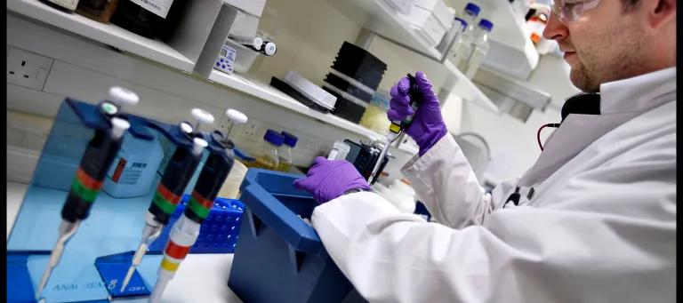Student with pipette at lab bench