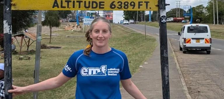 Amy under a sign showing that this is as the equator