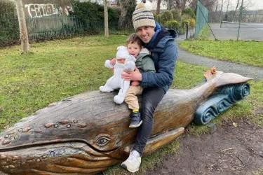 Kyle Ewart with his kids (sitting on a wooden whale)