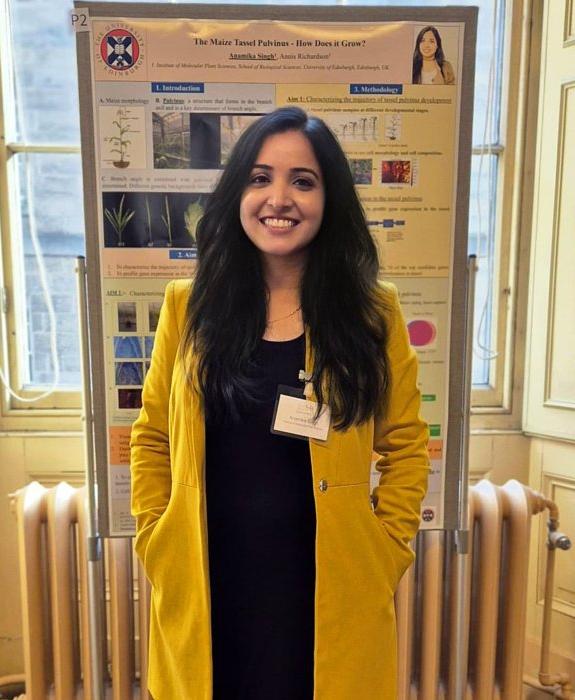 Anamika in front of an academic poster